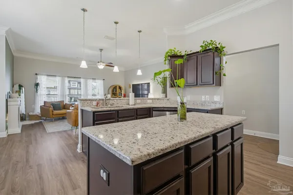 a kitchen with a counter top space cabinets and wooden floor