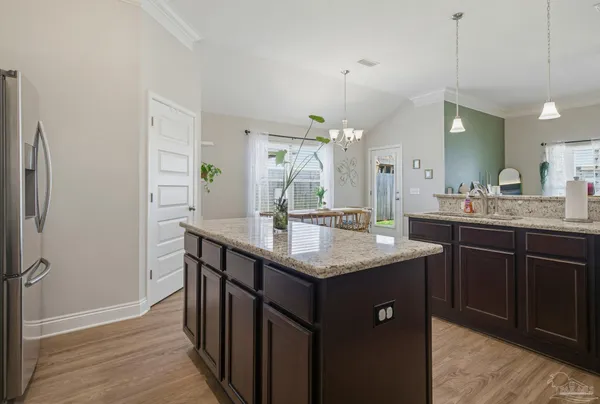 a kitchen with a sink a counter space and wooden floor