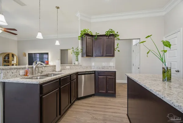 a kitchen with kitchen island granite countertop a sink a counter space and cabinets