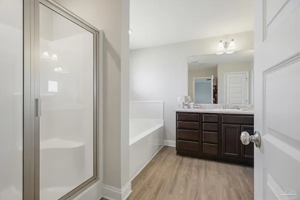 a bathroom with a double vanity sink a mirror and a bathtub