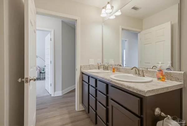 a bathroom with a granite countertop sink a toilet and a mirror