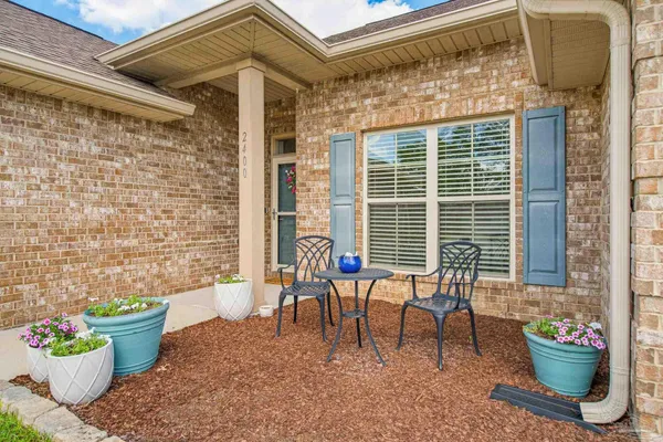 a view of a patio with couple of chairs and a potted plant