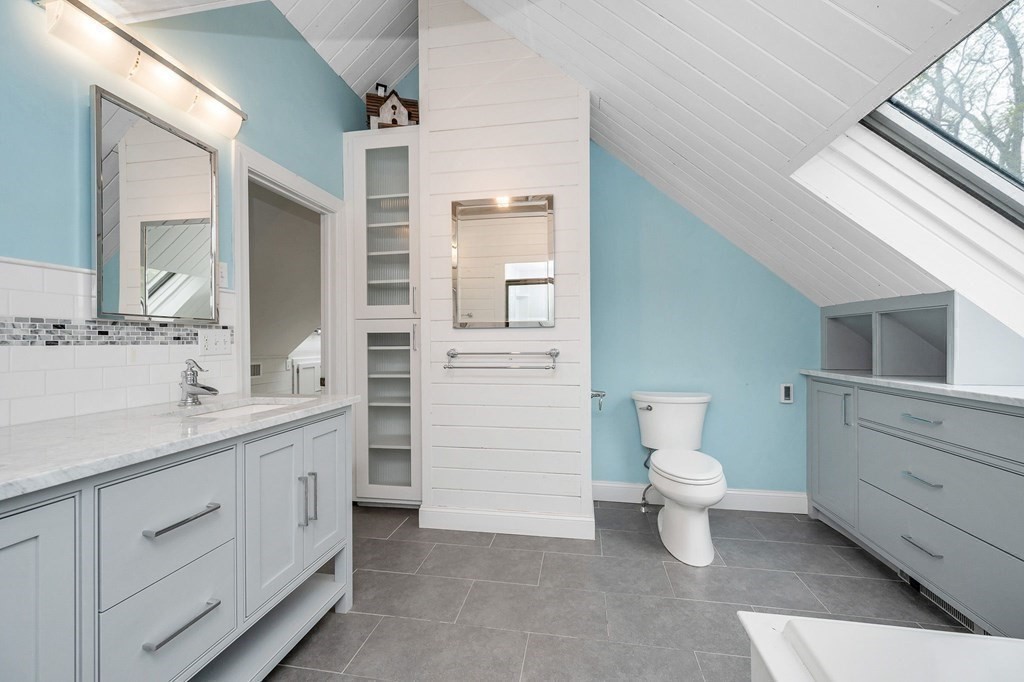 149 Pleasant Valley Road Amesbury, MA 01913 - Photo 24 of 42 a bathroom with a double vanity sink a toilet and a mirror