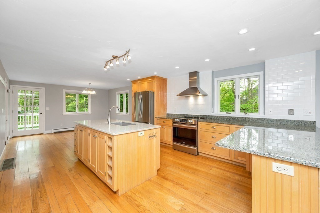 149 Pleasant Valley Road Amesbury, MA 01913 - Photo 5 of 42 a kitchen with a stove a sink and a wooden cabinets