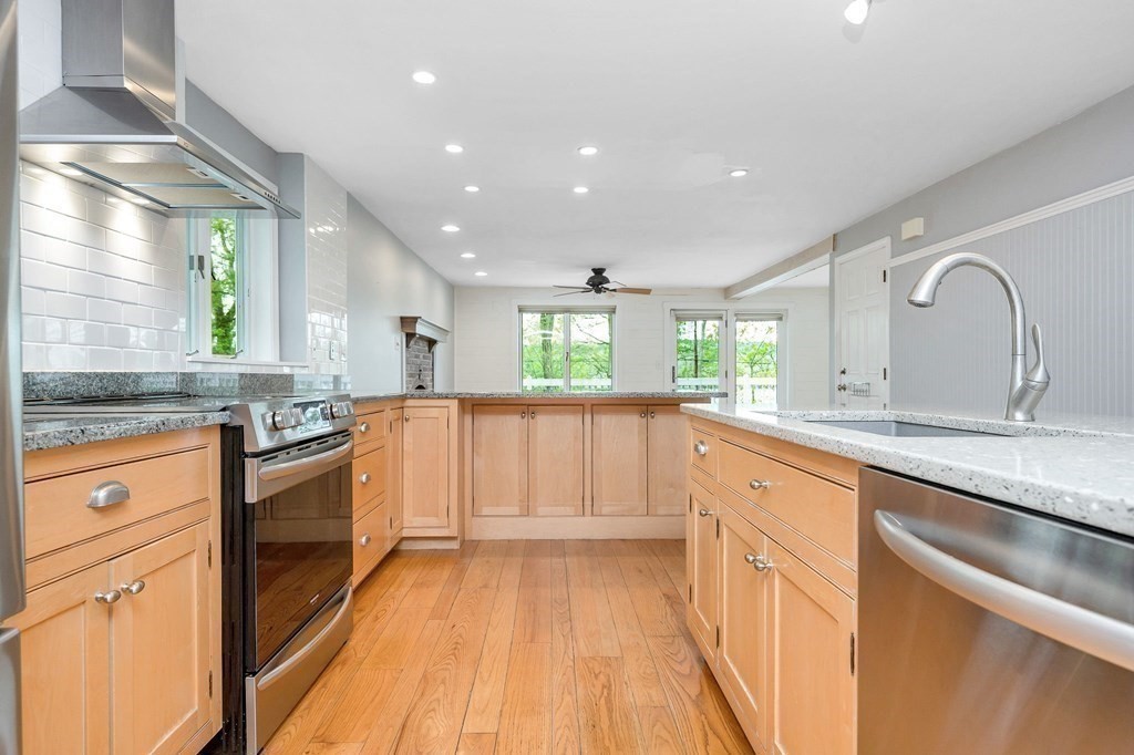 149 Pleasant Valley Road Amesbury, MA 01913 - Photo 8 of 42 a large kitchen with granite countertop a large counter top a sink stainless steel appliances and cabinets