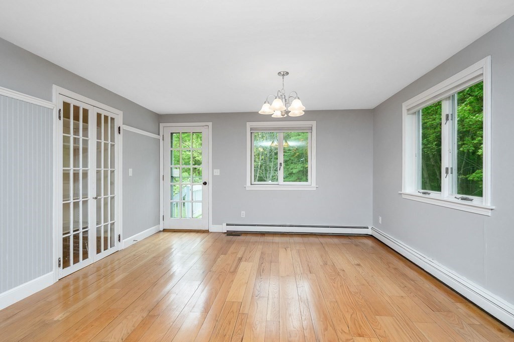 149 Pleasant Valley Road Amesbury, MA 01913 - Photo 9 of 42 an empty room with wooden floor and windows
