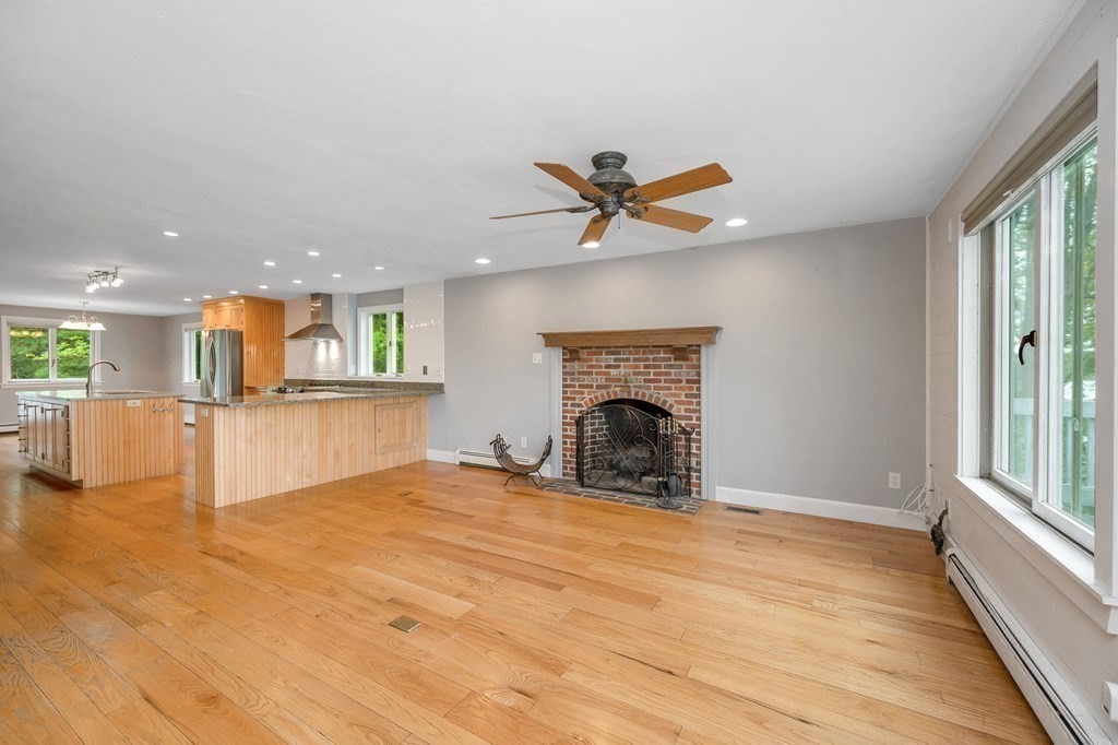 149 Pleasant Valley Road Amesbury, MA 01913 - Photo 10 of 42 a view of a livingroom with a fireplace a ceiling fan and window
