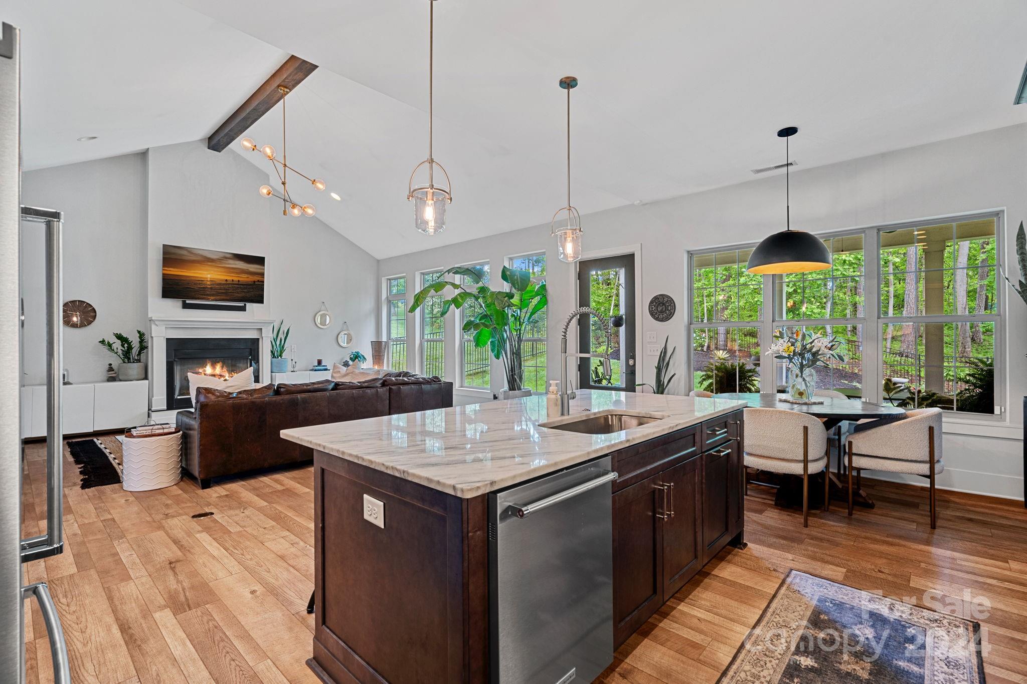 203 Webbed Foot Road Mooresville, NC 28117 - Photo 14 of 34 a kitchen with a stove a sink a dining table and chairs with wooden floor