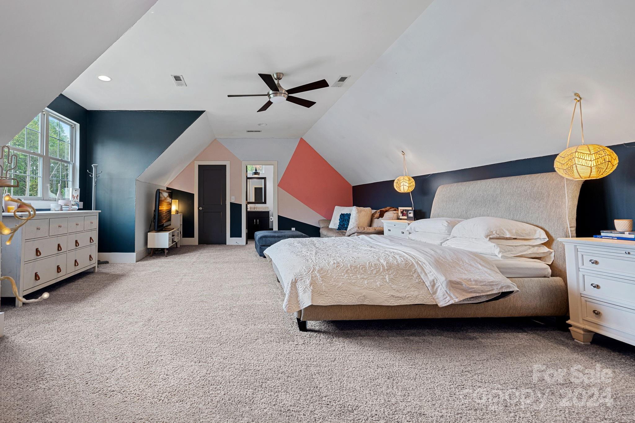 203 Webbed Foot Road Mooresville, NC 28117 - Photo 21 of 34 a spacious bedroom with a bed and a chandelier