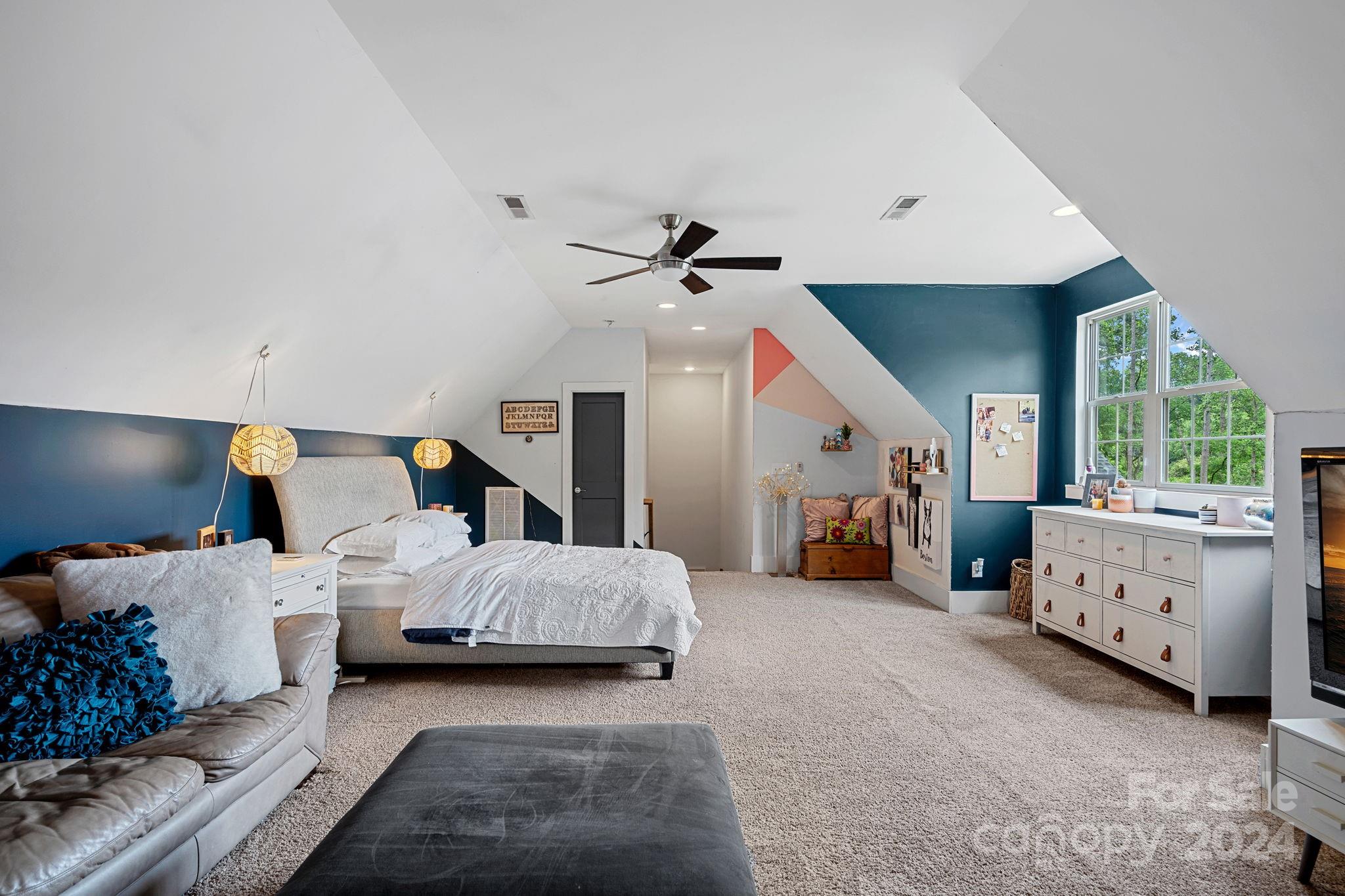 203 Webbed Foot Road Mooresville, NC 28117 - Photo 22 of 34 a spacious bedroom with a bed and a chandelier