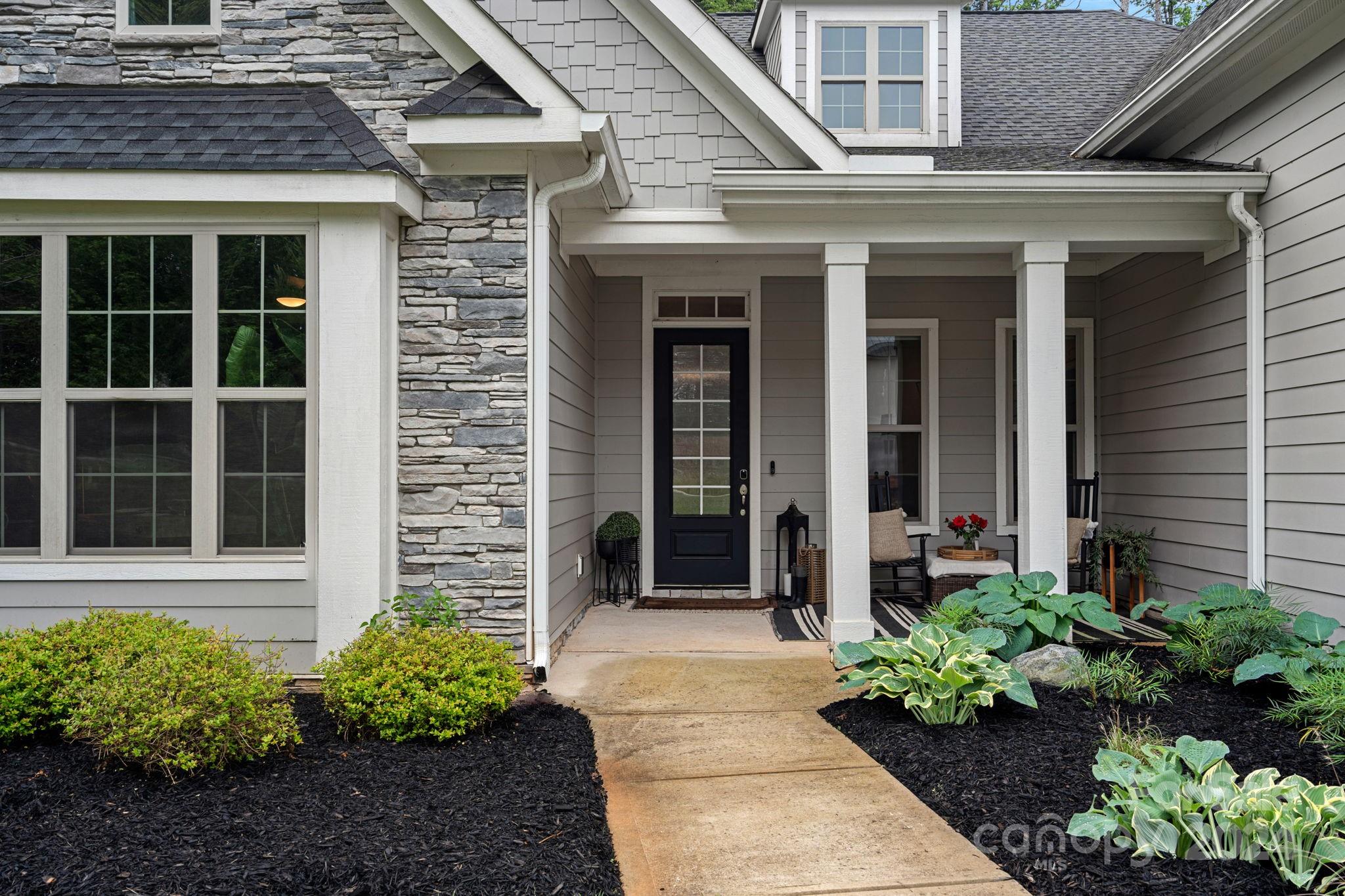 203 Webbed Foot Road Mooresville, NC 28117 - Photo 3 of 34 a view of a brick house with a flower garden