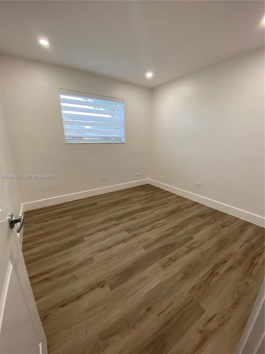 6829 Northwest 12th Street, Unit 6829 Plantation, FL 33313 - Photo 14 of 27 an empty room with wooden floor and windows