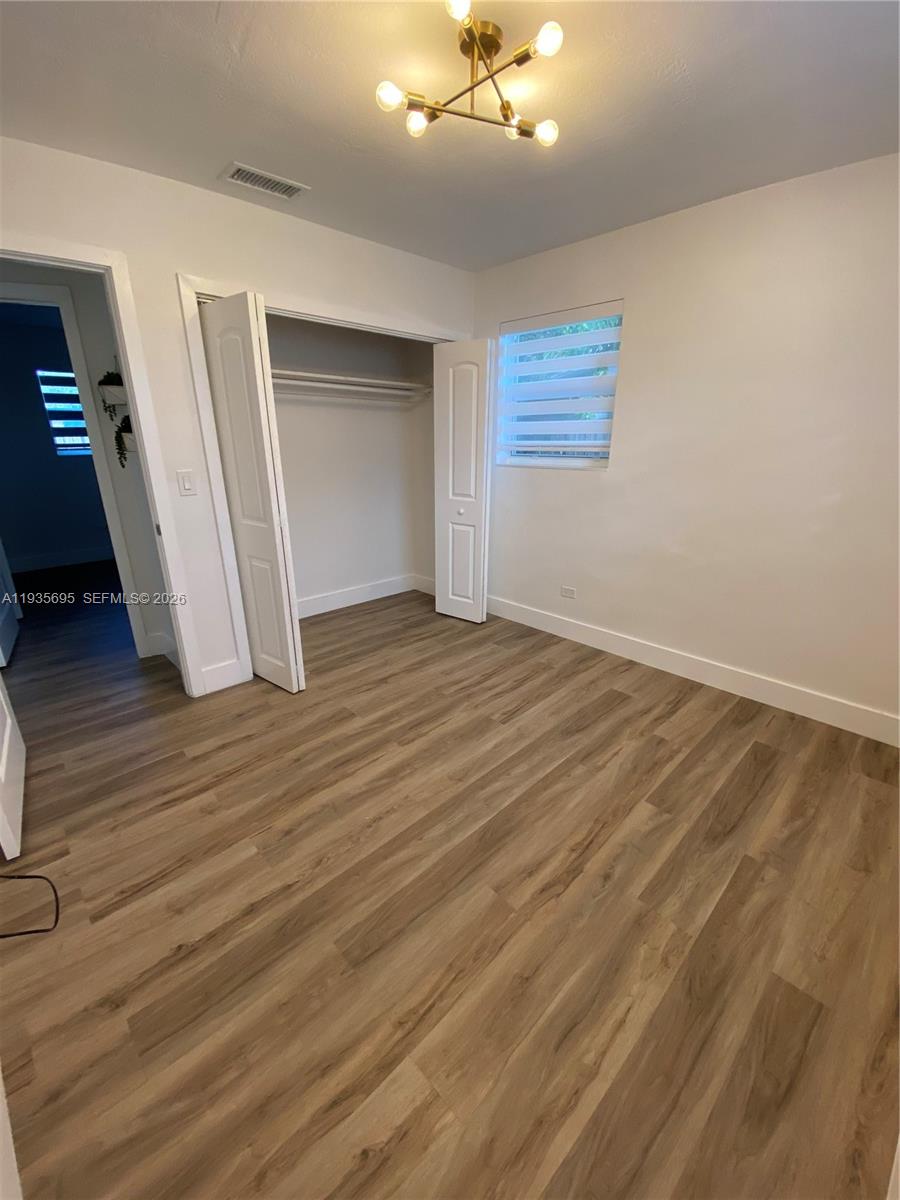 6829 Northwest 12th Street, Unit 6829 Plantation, FL 33313 - Photo 16 of 27 a view of an empty room with wooden floor and a window