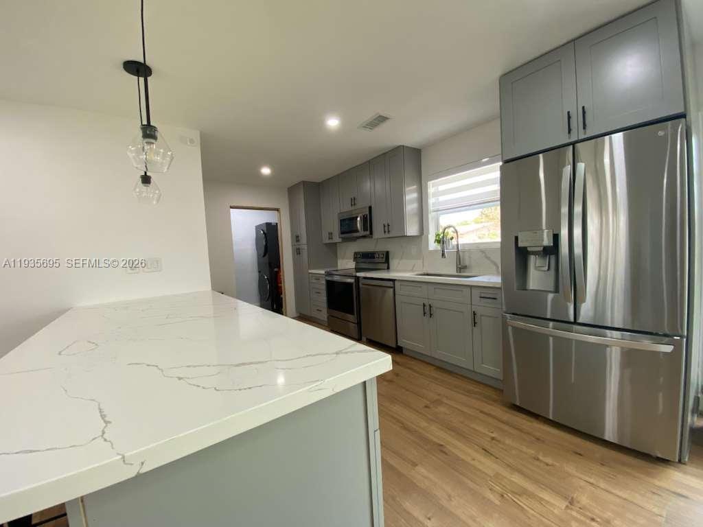 6829 Northwest 12th Street, Unit 6829 Plantation, FL 33313 - Photo 4 of 27 a kitchen with stainless steel appliances a refrigerator sink and wooden floor