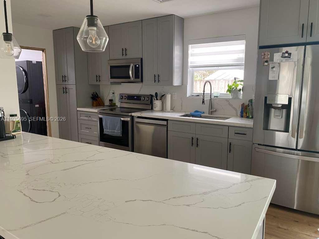 6829 Northwest 12th Street, Unit 6829 Plantation, FL 33313 - Photo 5 of 27 a kitchen with stainless steel appliances a refrigerator sink and cabinets