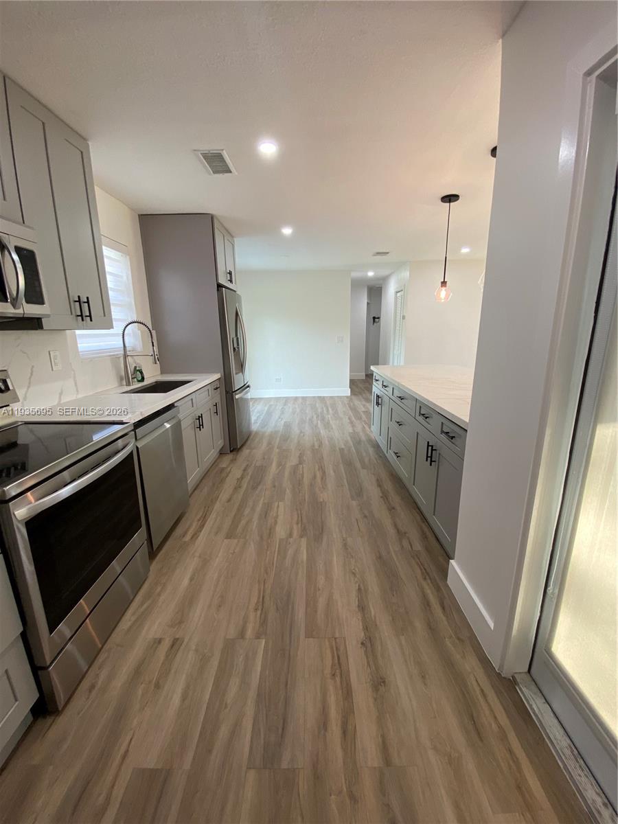 6829 Northwest 12th Street, Unit 6829 Plantation, FL 33313 - Photo 8 of 27 a kitchen with stainless steel appliances granite countertop a stove and a sink