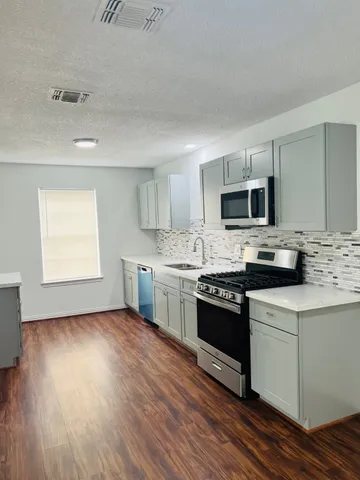 a kitchen with a stove a sink and a microwave
