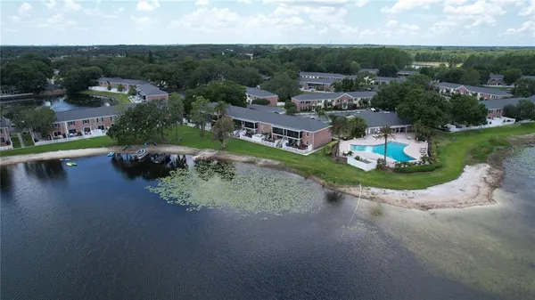 an aerial view of a residential houses with outdoor space and lake view