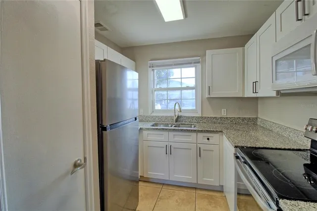 a kitchen with granite countertop cabinets stainless steel appliances and a counter space