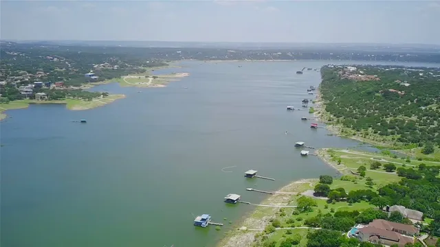 an aerial view of ocean and residential houses with outdoor space