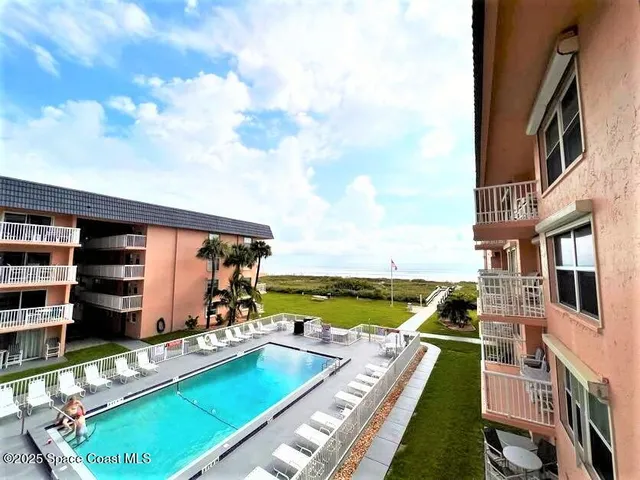 a view of swimming pool with outdoor seating and a garden