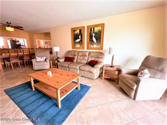 a living room with furniture a table and a potted plant