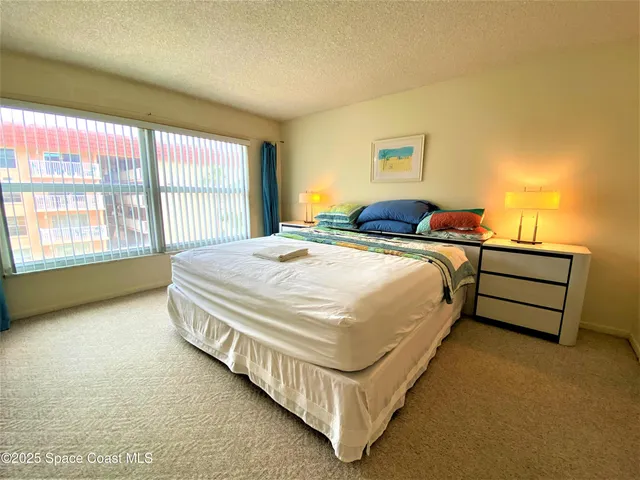 a bed sitting in a bedroom next to a window