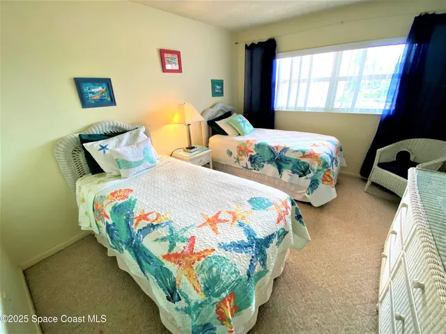 a bedroom with two beds and a window