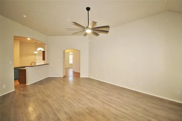 a view of a kitchen with wooden floor and a ceiling fan