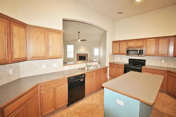 a kitchen with a sink a stove top oven and cabinetry