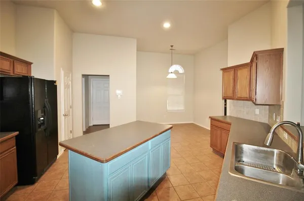 a kitchen with stainless steel appliances granite countertop a sink and a refrigerator