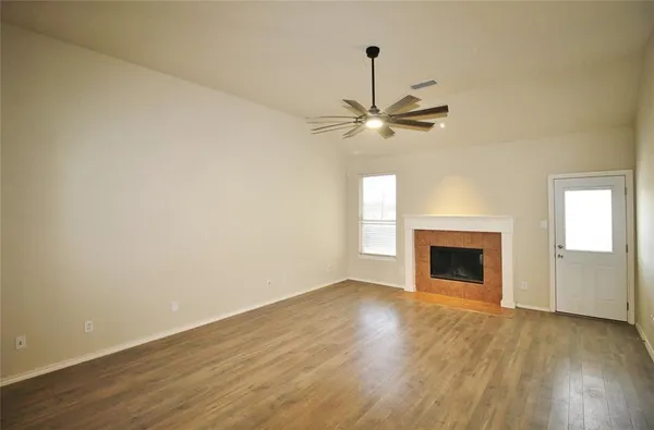 a view of an empty room with a fireplace and a window
