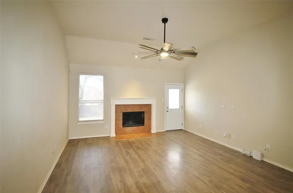 a view of an empty room with a fireplace and a window