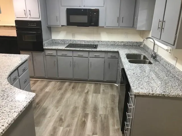 a kitchen with granite countertop a sink and a stove