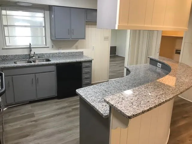 a kitchen with granite countertop a sink and a stove