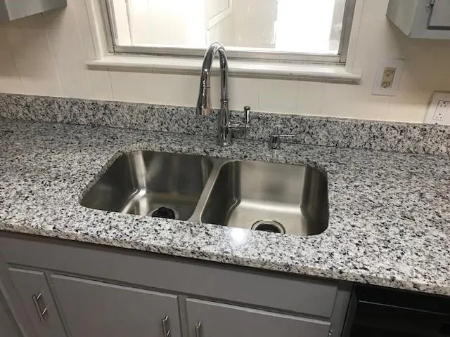 a kitchen with a sink and granite counter tops