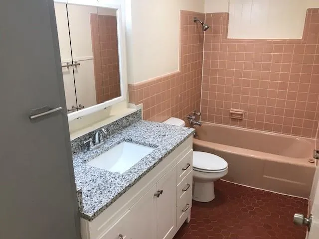 a bathroom with a granite countertop sink and a mirror
