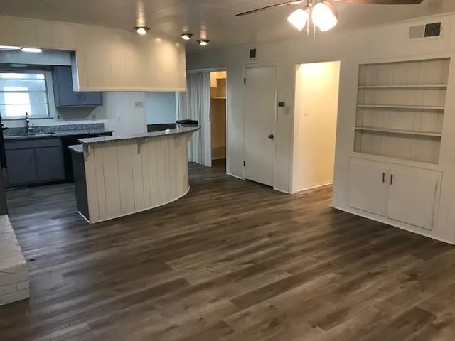 a kitchen with wooden floors and cabinets