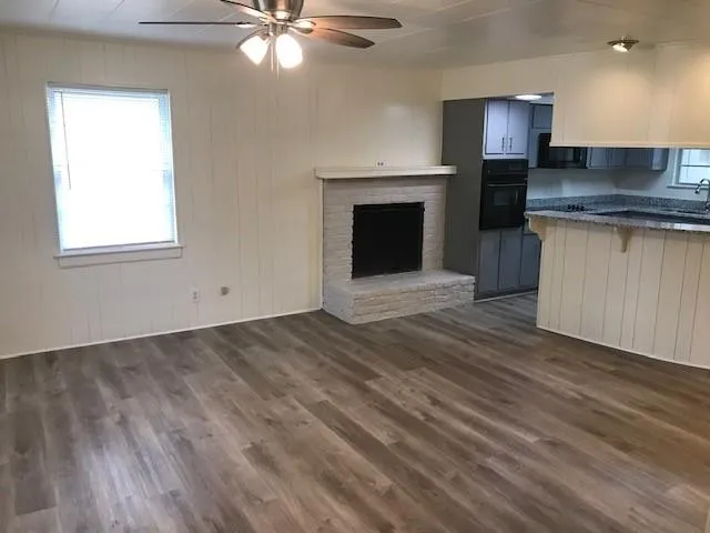 a kitchen with granite countertop a stove a sink and a fireplace