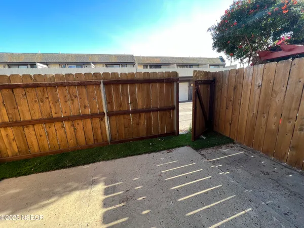a view of a backyard with wooden fence