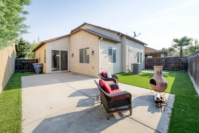 a backyard of a house with table and chairs
