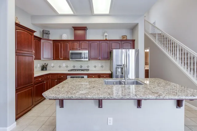 a kitchen with stainless steel appliances granite countertop a sink refrigerator and microwave