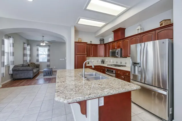 a kitchen with kitchen island a counter top space a sink and appliances
