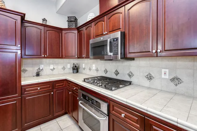 a kitchen with stainless steel appliances granite countertop a sink stove and cabinets