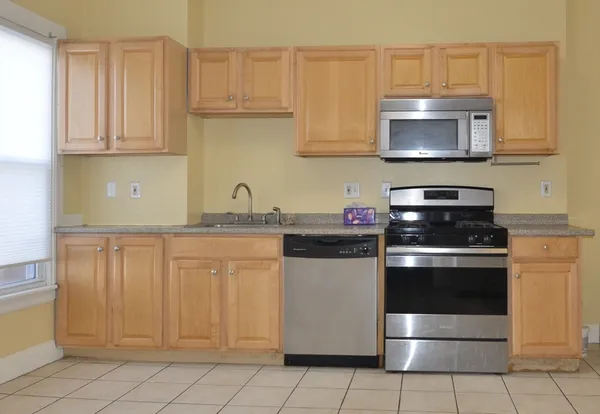 a kitchen with granite countertop white cabinets and stainless steel appliances