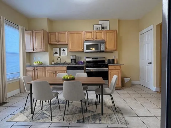 a kitchen with stainless steel appliances a white table and chairs in it