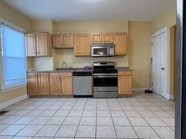 a kitchen with stainless steel appliances a stove a sink and a refrigerator
