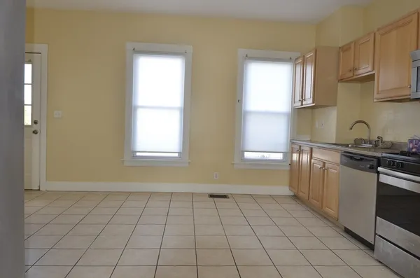 a kitchen with a sink a stove cabinets and a window