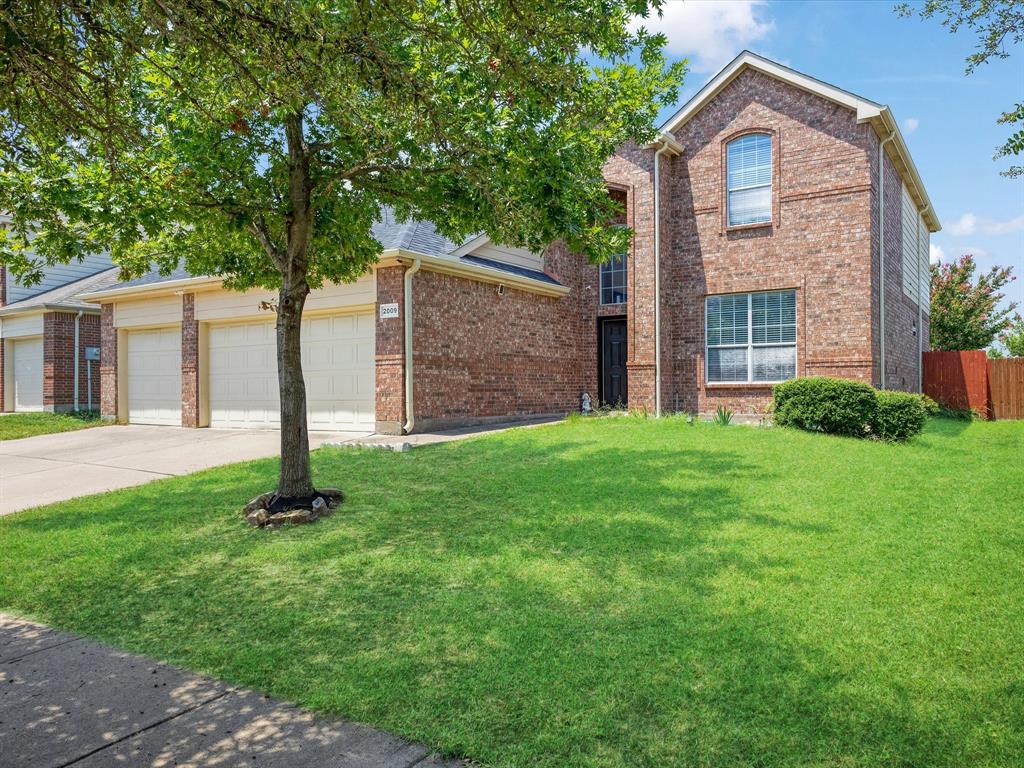 Traditional-style house with brick siding, concrete driveway, and a garage