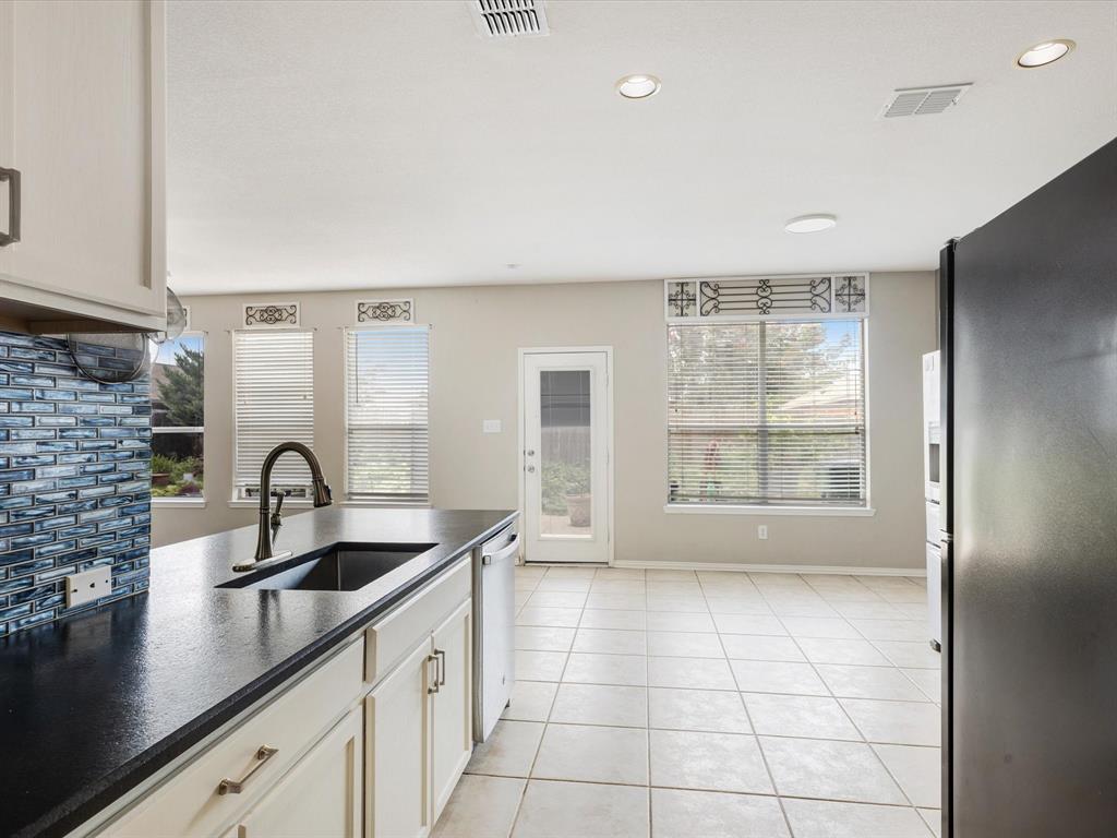 2009 Cooper Ridge Lane Heartland, TX 75126 - Photo 16 of 40 Kitchen with dark countertops, appliances with stainless steel finishes, light tile patterned flooring, and recessed lighting
